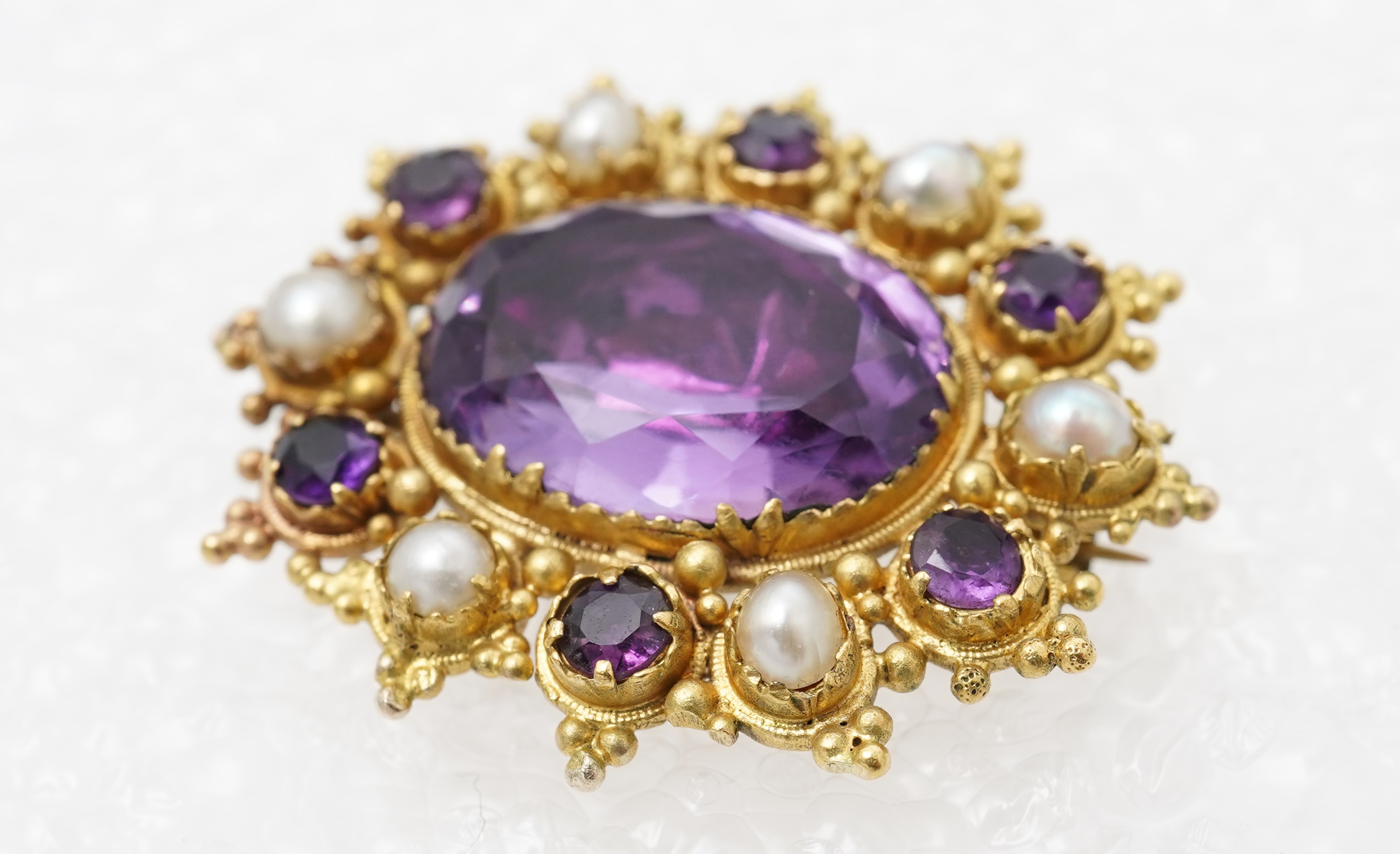 An amethyst and split pearl brooch, mid 19th century